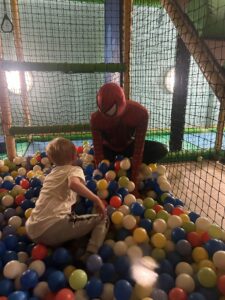 Spiderman in ball pit with child